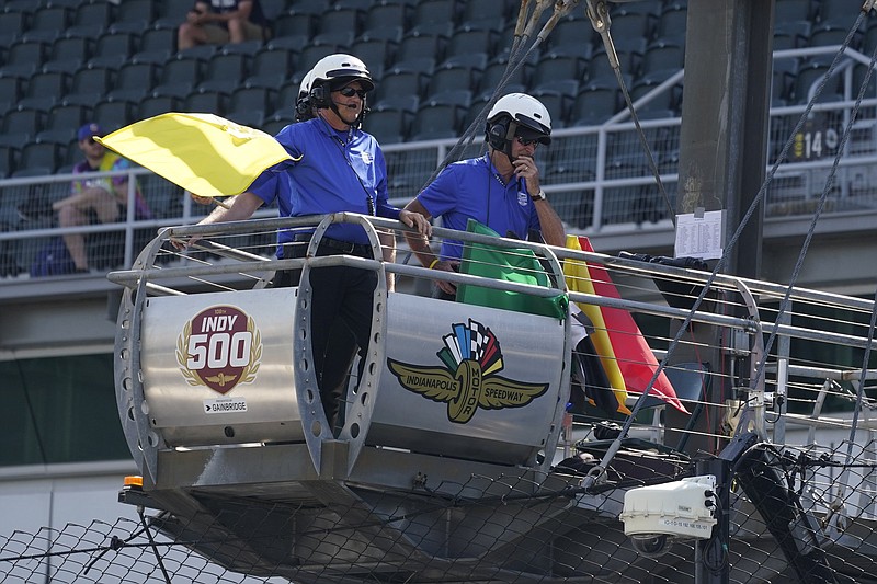 An official holds the yellow flag as it blows in the wind Friday during practice for the Indianapolis 500 at Indianapolis Motor Speedway. Winds reached 41 mph during Friday’s session as race officials scrambled to save qualifying for the race.
(AP Photo/Darron Cummings)