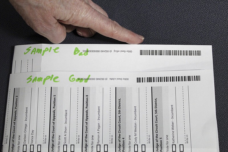 An election worker at the Clackamas County (Ore.) Elections office in Oregon City, Ore., shows barcodes on ballots that are bad (top) and good on Thursday, May 19, 2022. Ballots with blurry barcodes that can't be read by vote-counting machines will delay election results by weeks in a key U.S. House race in Oregon's primary. (AP/Gillian Flaccus)