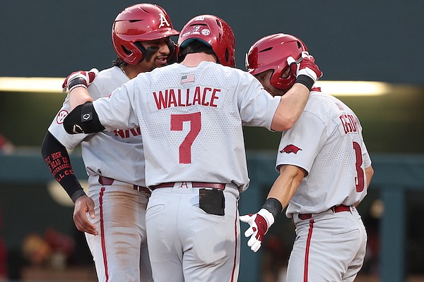 Arkansas third baseman Cayden Wallace (center) is greeted by Jalen Battles (left) and Zack Gregory (right) after Wallace hit a go-ahead home run during the fifth inning of a game against Alabama on Thursday, May 19, 2022, in Tuscaloosa, Ala. (Photo courtesy Alabama Athletics, via SEC Media Portal)