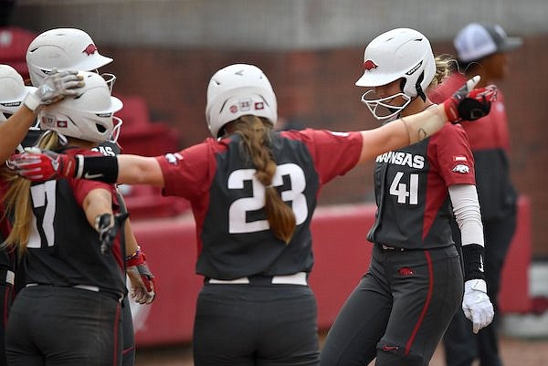 Arkansas first baseman Danielle Gibson (41) is congratulated at the plate Friday, May 20, 2022, after hitting a grand slam during the fourth inning of the Razorbacks' 11-0 run-rule-shortened win over Princeton at Bogle Park in Fayetteville.