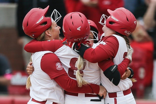 Arkansas players hug after a score, Sunday, May 22, 2022 during the sixth inning of the championship game of the Fayetteville Regional Softball Tournament at Bogle Park in Fayetteville. Check out nwaonline.com/220523Daily/ and nwadg.com/photos for the photo gallery.