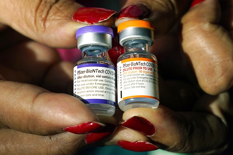 FILE - A nurse holds a vial of the Pfizer covid-19 vaccine for children ages 5 to 11, right, and a vial of the vaccine for adults, which has a different colored label, at a vaccination station in Jackson, Miss., Tuesday, Feb. 8, 2022. (AP/Rogelio V. Solis, File)