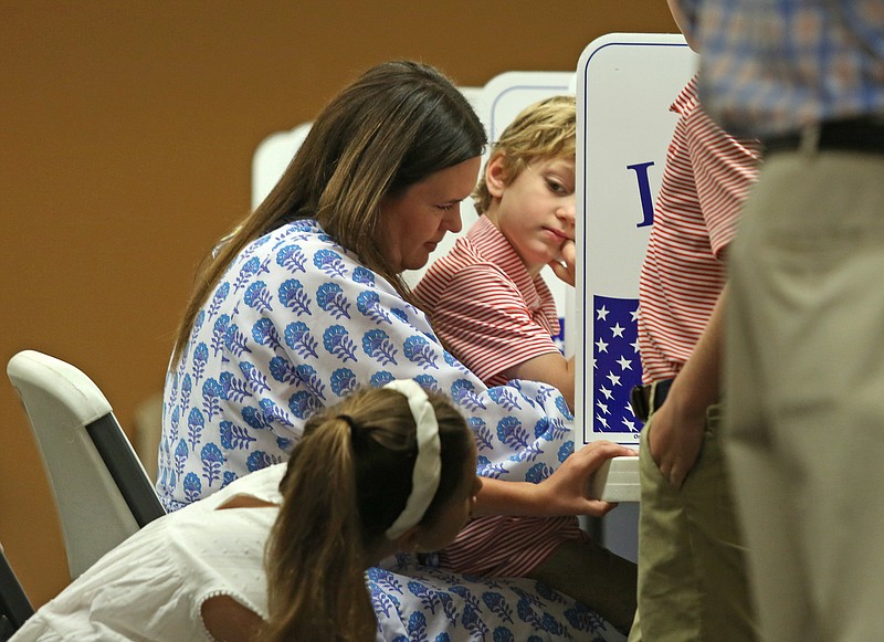 Gubernatorial candidate Sarah Huckabee Sanders, center, casts her vote with children Scarlett, left, and George at a polling station located in the Pleasant Valley Church of Christ in Little Rock on Tuesday, May 24, 2022. (Arkansas Democrat-Gazette/Colin Murphey)