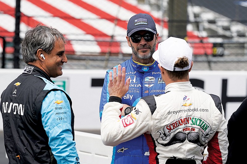 Jimmie Johnson (center) talks with Juan Pablo Montoya (left) and Santino Ferrucci before practice Monday for the Indianapolis 500 at Indianapolis Motor Speedway in Indianapolis. (Associated Press)