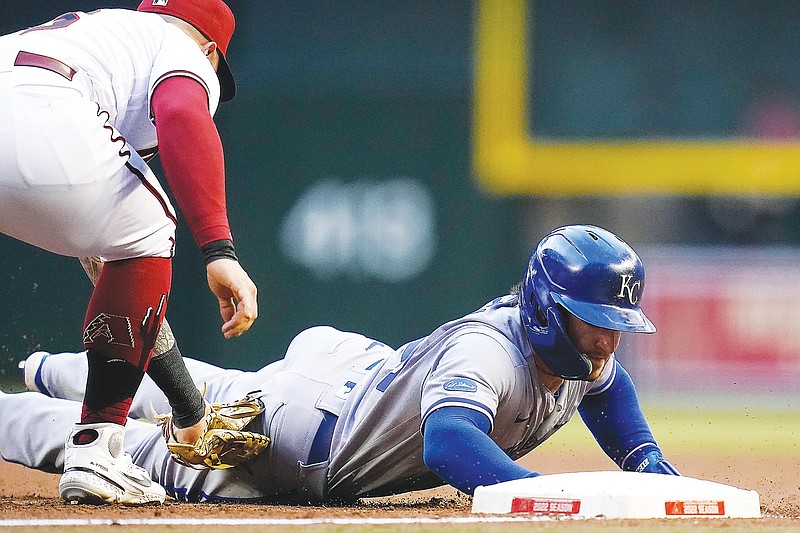 Kyle Isbel of the Royals dives safely back to first base as Diamondbacks first baseman Christian Walker applies a late tag during Monday night's game in Phoenix. (Associated Press)