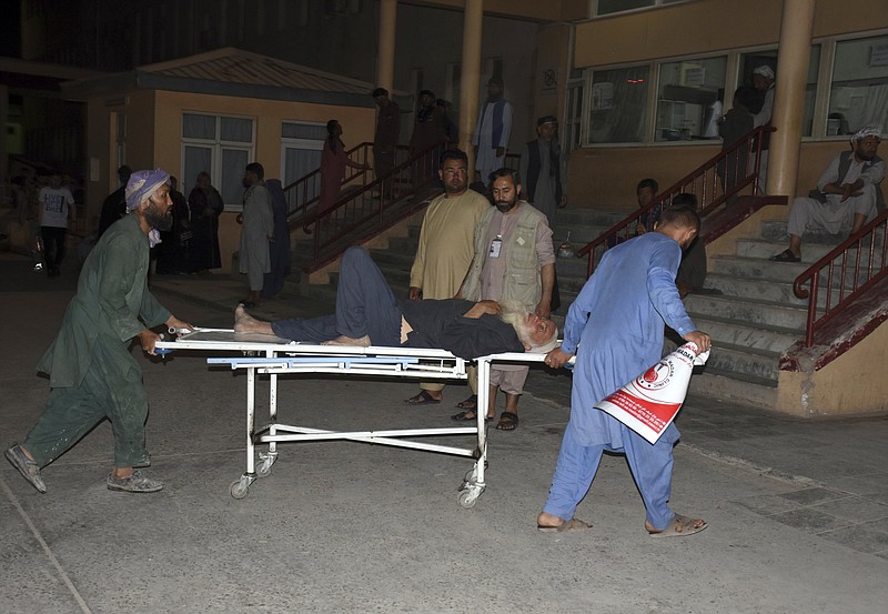 An injured man is carried to a hospital after a bombing Wednesday in Mazar-e-Sharif, northern Afghanistan.
(AP/Masih Paeiz)