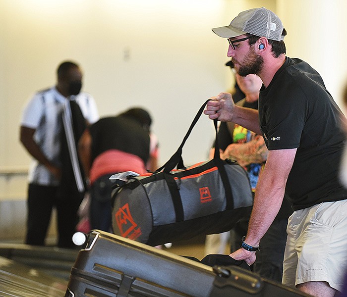 Grant Carter of Hot Springs grabs his baggage from the carousel Wednesday at Bill and Hillary Clinton National Airport/Adams Field in Little Rock.
(Arkansas Democrat-Gazette/Staci Vandagriff)
