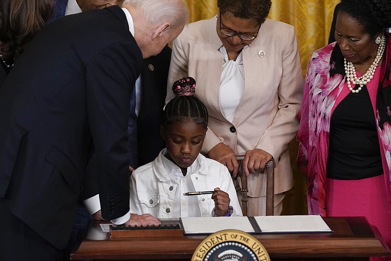 President Joe Biden gives a pen to Gianna Floyd, the daughter of George Floyd, after he signed an executive order Wednesday in the East Room of the White House in Washington. Watching are Rep. Karen Bass, D-Calif., and Rep. Sheila Jackson Lee, D-Texas.
(AP/Alex Brandon)