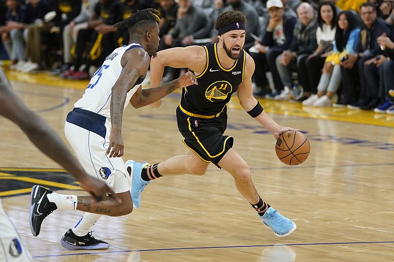 Golden State Warriors guard Klay Thompson (right) dribbles past Reggie Bullock of the Dallas Mavericks during the second half of Game 5 of the NBA Western Conference finals on Thursday in San Francisco. Thompson had 32 points to lead the Warriors to a 120-110 victory as they won the series 4-1. More photos available at arkansasonline.com/527game5/.
(AP/Jeff Chiu)