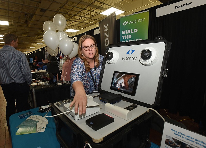 Franci Heflin Wachter with Wachter Inc., an electronics and technology company, shows how an access control system works during the Rogers-Lowell Area Chamber of Commerce Job Fair at Frisco Station Mall in Rogers in this May 4, 2022 file photo. (NWA Democrat-Gazette/Flip Putthoff)