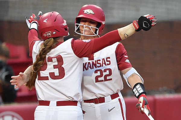Arkansas left fielder Hannah McEwen (23) celebrates Thursday, May 26, 2022, with designated hitter Linnie Malkin after scoring the Razorbacks’ first run on a single by third baseman Hannah Gammill during the fifth inning of the Razorbacks’ 7-1 win over Texas in the Fayetteville Super Regional at Bogle Park in Fayetteville.