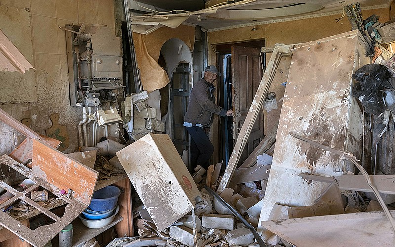 A man who gave his name as Alexander, 67, checks over his neighbor’s apartment that was destroyed by Russian shelling Friday in Kutuzivka, near Kharkiv in eastern Ukraine. More photos at arkansasonline.com/ukrainemonth4/.
(AP/Bernat Armangue)