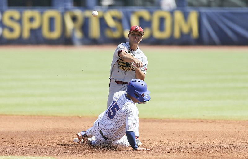 Arkansas second baseman Robert Moore throws to first to complete a double play after forcing out Florida catcher BT Riopelle during the fourth inning Friday at the SEC Baseball Tournament at Hoover Metropolitan Stadium in Hoover, Ala. The Razorbacks lost 7-5 and were eliminated from the tournament. More photos at arkansasonline.com/528flaua/
(NWA Democrat-Gazette/Charlie Kaijo)