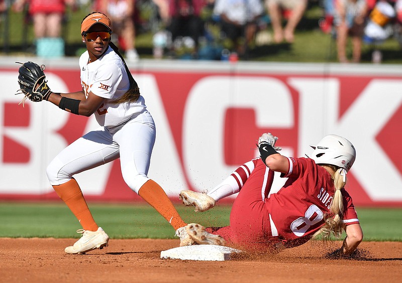 Texas second baseman Janae Jefferson (left) forces out Arkansas center fielder KB Sides during the first inning of Friday’s game in Fayetteville. Jefferson made a diving stop for the final out of the third inning after a 20-pitch at-bat by Arkansas’ Hannah Gammill.
(NWA Democrat-Gazette/Andy Shupe)