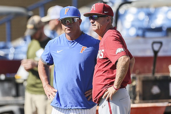 Arkansas coach Dave Van Horn (right) speaks with Florida coach Kevin O'Sullivan prior to an SEC Tournament game between their teams Friday, May 27, 2022, in Hoover, Ala.