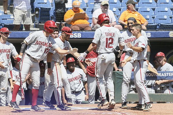 Arkansas players congratulate Michael Turner (12) after Turner hit a home run during an SEC Tournament game against Florida on Friday, May 27, 2022, in Hoover, Ala.