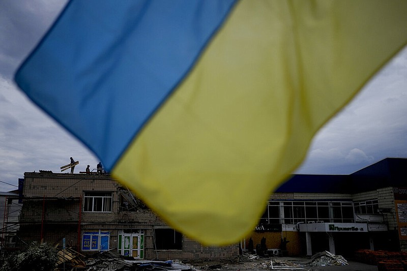 Men work at repairing a building damaged by shelling in Makariv, on the outskirts of Kyiv, Ukraine, Friday, May 27, 2022. (AP/Natacha Pisarenko)