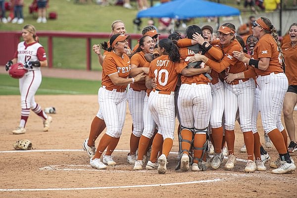 Texas players celebrate after clinching a trip to the Women's College World Series with a 3-0 victory over Arkansas on Saturday, May 28, 2022, in Fayetteville.