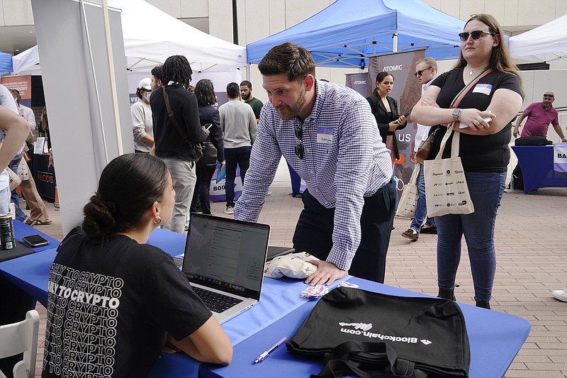 A Blockchain.com employee talks to a job seeker about openings at the company during the Venture Miami Tech Hiring Fair in this April file photo. Employers advertised 11.4 million jobs at the end of April, the Labor Department said Wednesday.
(AP)