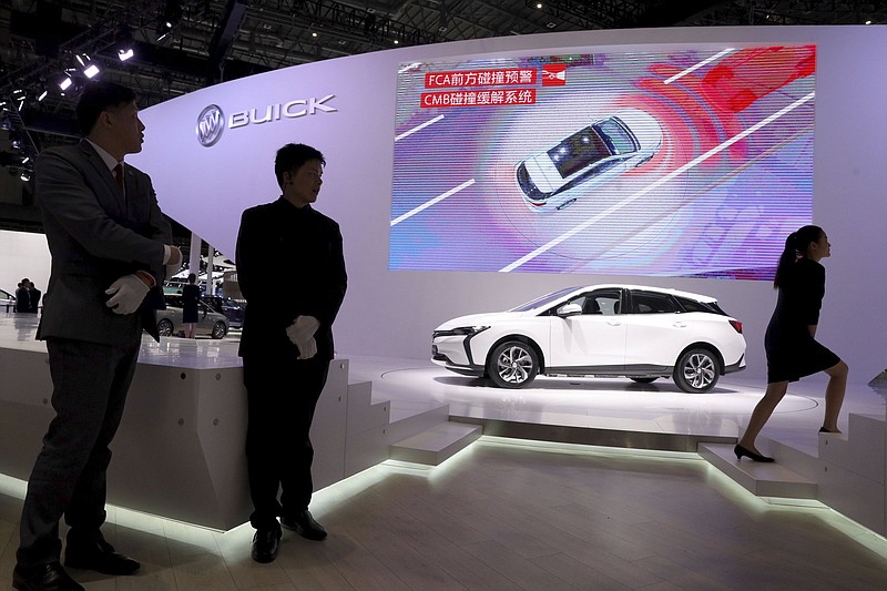 Staff members stand near the Velite 6, Buick’s first all-electric model for China during the Auto Shanghai 2019 show in Shanghai.
(AP/Ng Han Guan)