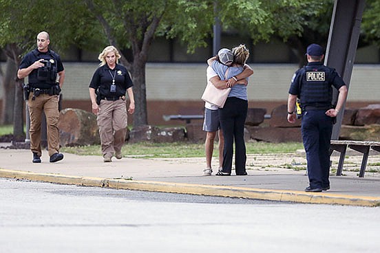 People hug outside Memorial High School in Tulsa, where families could be reunited Wednesday after people were evacuated from the scene of a shooting at the Natalie Medical Building.
(AP/Tulsa World/Ian Maule)