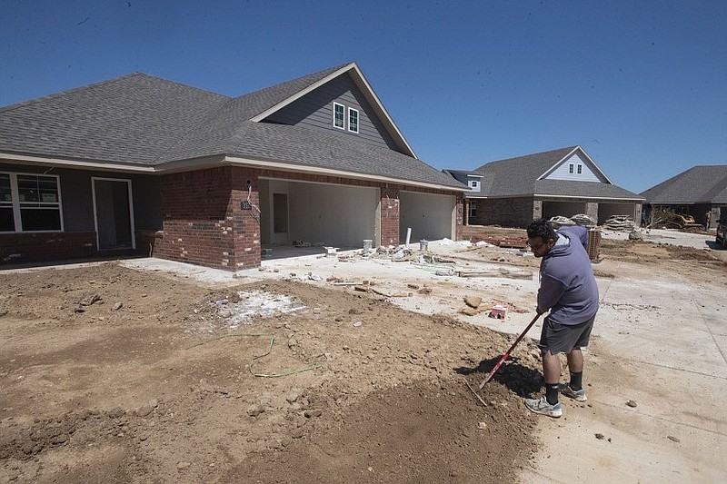 Hector Sandoval of Rogers smooths the yard at a newly constructed house in Farmington in this May 16, 2022 file photo. (NWA Democrat-Gazette/J.T. Wampler)