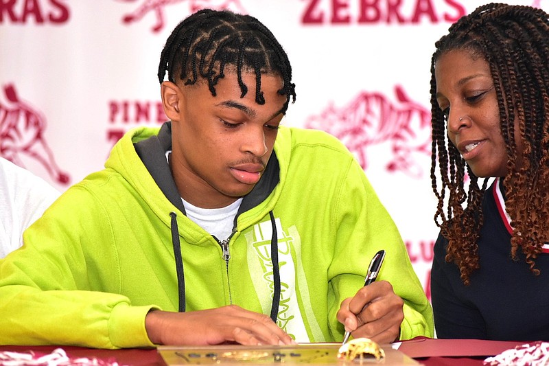 Pine Bluff High School graduate Troy'reon Ramos signs a letter of intent with Arkansas Baptist College as his grandmother Karen Brentley looks on Thursday, June 2, 2022, at the PBHS student center. 
(Pine Bluff Commercial/I.C. Murrell)