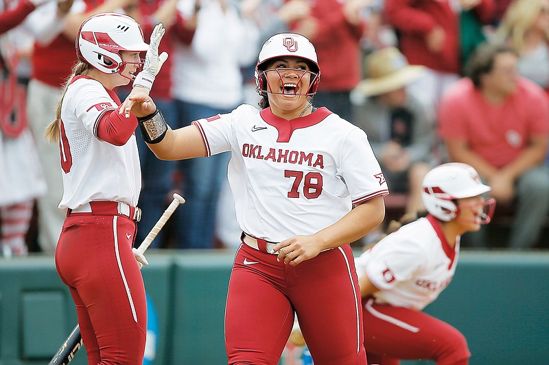 In this May 22 file photo, Oklahoma’s Jocelyn Alo celebrates with Jana Johns after scoring a run against Texas A&M during the NCAA Norman Regional in Norman, Okla. (Associated Press)