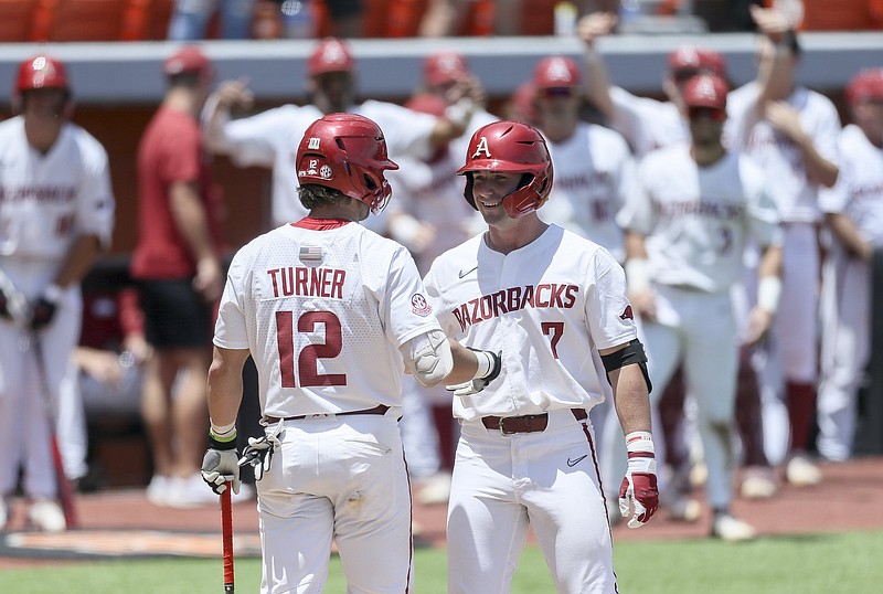 Arkansas catcher Michael Turner (left) greets third baseman Cayden Wallace after Wallace hit a home run during the fourth inning of the NCAA Stillwater Regional on Friday at O’Brate Stadium in Stillwater, Okla. The Razorbacks snapped a four-game losing streak with a 7-1 victory. More photos at arkansasonline.com/64gcuua/
(NWA Democrat-Gazette/Charlie Kaijo)