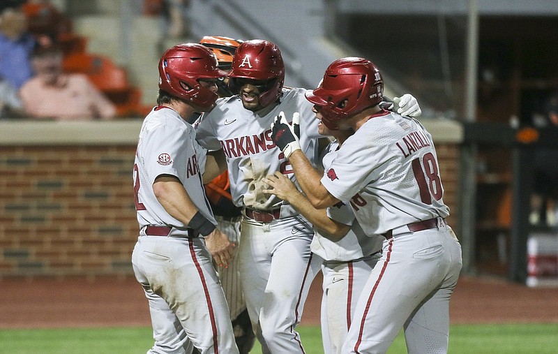 Arkansas shortstop Jalen Battles (center) is greeted at home plate after hitting a grand slam during the eighth inning against Oklahoma State in the NCAA Stillwater Regional on Saturday at O’Brate Stadium in Stillwater, Okla. Arkansas won 20-12. More photos at arkansasonline.com/65osuua/
(NWA Democrat-Gazette/Charlie Kaijo)