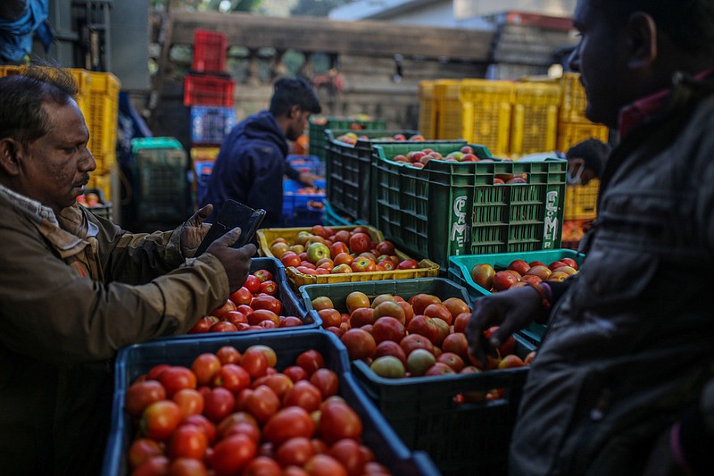 A vendor sells tomatoes at a wholesale vegetable market in Bengaluru, India, in February.
(Bloomberg (WPNS)/Dhiraj Singh)