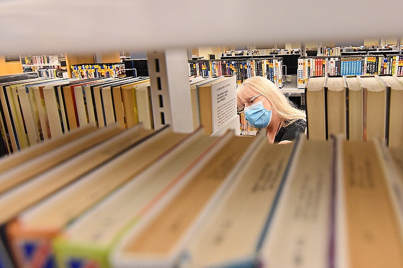 Renee Morrison, an adult services associate, re-shelves books  at William F. Laman Public Library’s main branch in North Little Rock in this May 10, 2021 file photo. (Arkansas Democrat-Gazette/Staci Vandagriff)