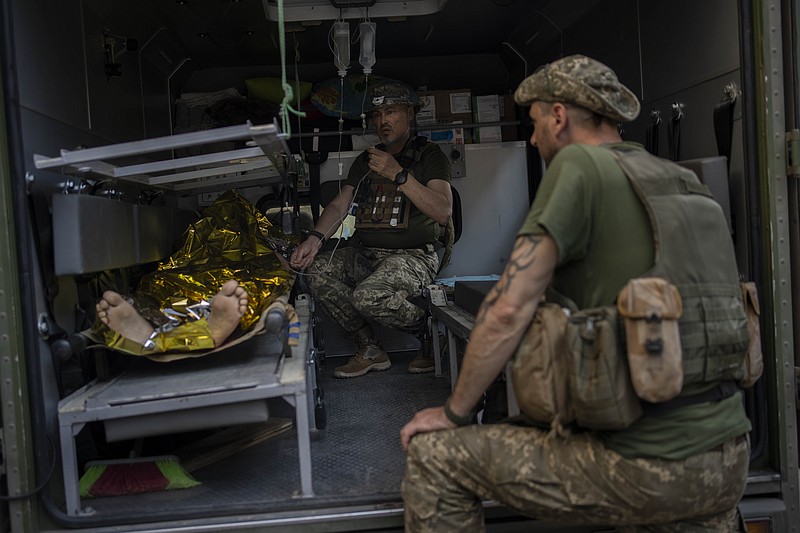 An injured Ukrainian servicemen is transferred to a medical facility after getting an emergency medical treatment in the  Donetsk region, eastern Ukraine, Tuesday, June 7, 2022. (AP Photo/Bernat Armangue)