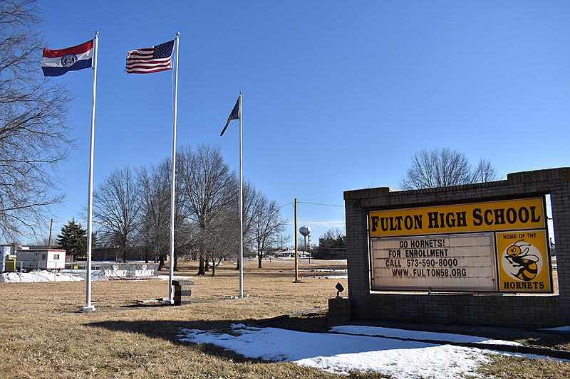 A school sign and flag poles stand outside Fulton High School in Fulton, Mo. (Fulton Sun file photo)