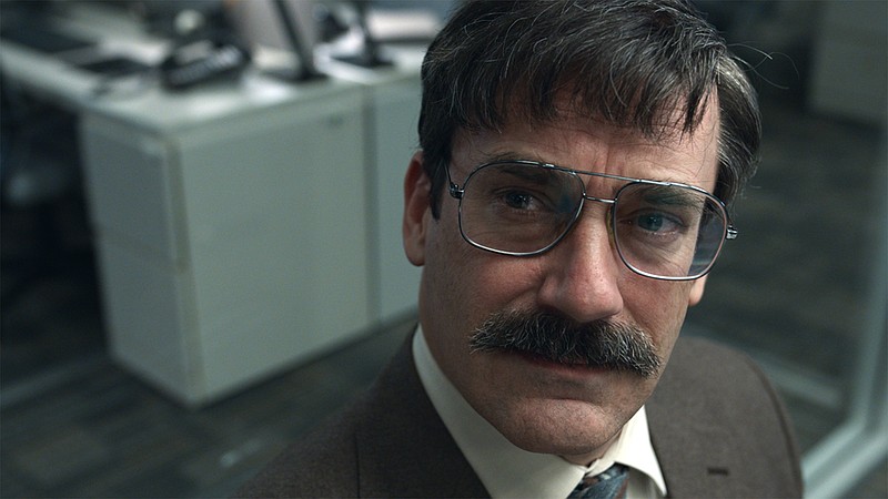 The moustache un-makes the man? Jon Hamm is Orson, a compulsive bureaucrat who takes refuge in a secret office he discovers in his workplace in Joachim Back’s Kafkaesque black comedy “Corner Office.”