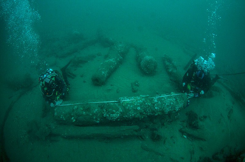 In this undated photo provided by Norfolk Historic Shipwrecks, Julian And Lincoln Barnwell measure the cannon found on the HMS Gloucester in 2007.  (Norfolk Historic Shipwrecks via AP)