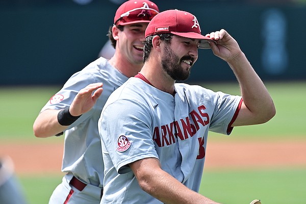 Arkansas pitcher Connor Noland (13) smiles and is congratulated by third baseman Cayden Wallace as he walks off the field during an NCAA Tournament game against North Carolina on Saturday, June 11, 2022, in Chapel Hill, N.C.