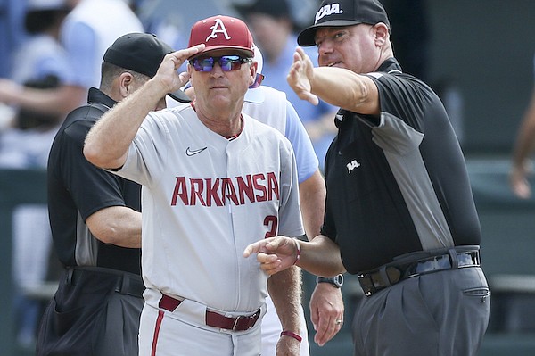 Arkansas coach Dave Van Horn (left) speaks with an umpire prior to an NCAA Tournament game against North Carolina on Saturday, June 11, 2022, in Chapel Hill, N.C.