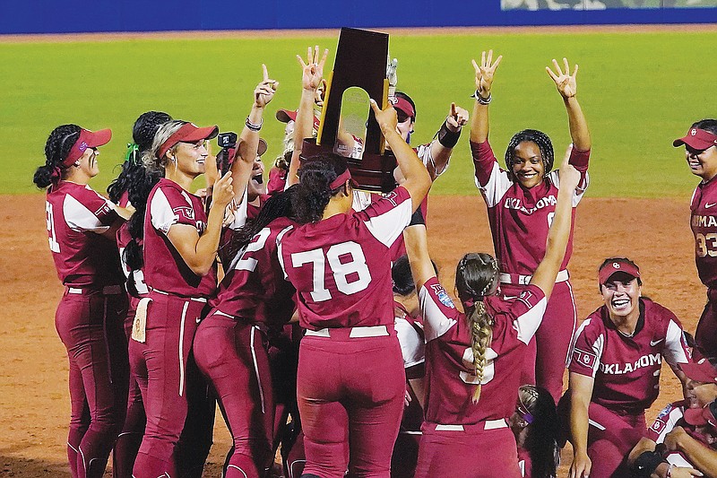 Oklahoma players celebrate with the trophy Thursday night after defeating Texas in the NCAA Women's College World Series softball finals in Oklahoma City. (Associated Press)