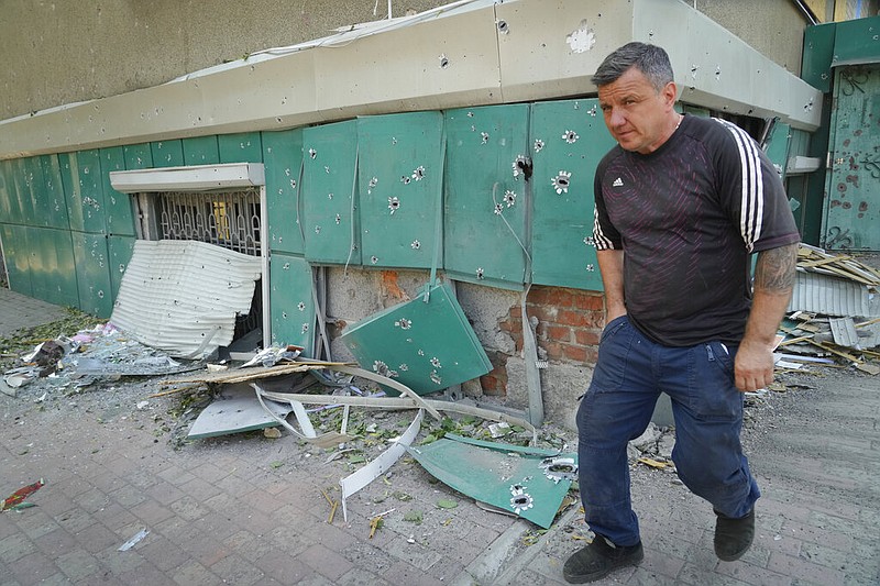 A local resident passes by shrapnel traces following Russian night shelling in the town of Bakhmut, Donetsk region, Ukraine, Monday, June 13, 2022. (AP/Efrem Lukatsky)