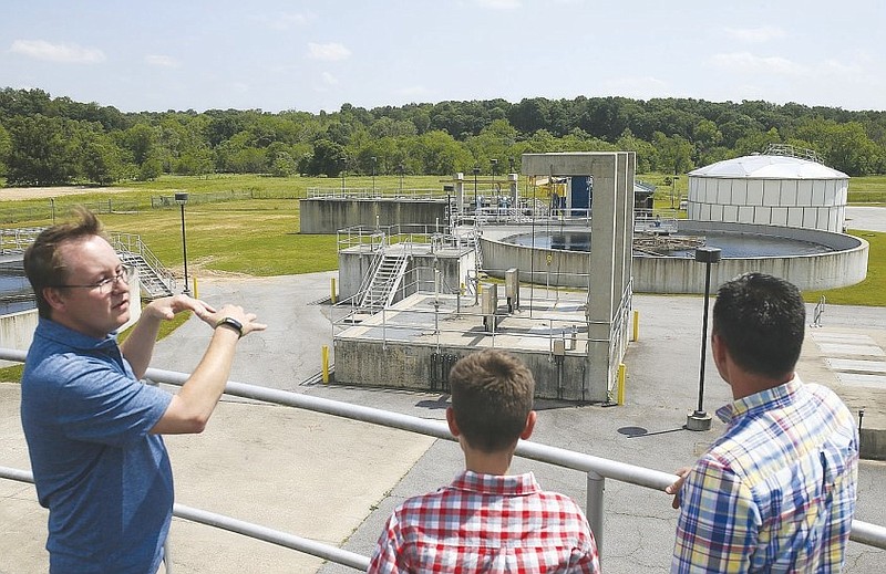 Mike Neil (from left), plant manager at the Northwest Arkansas Conservation Authority wastewater treatment plant in Bentonville, gives a tour as Nolan Burress and Tim Burress, a member of the Tontitown City Council, look on in this May 19, 2022 file photo. (NWA Democrat-Gazette/Charlie Kaijo)