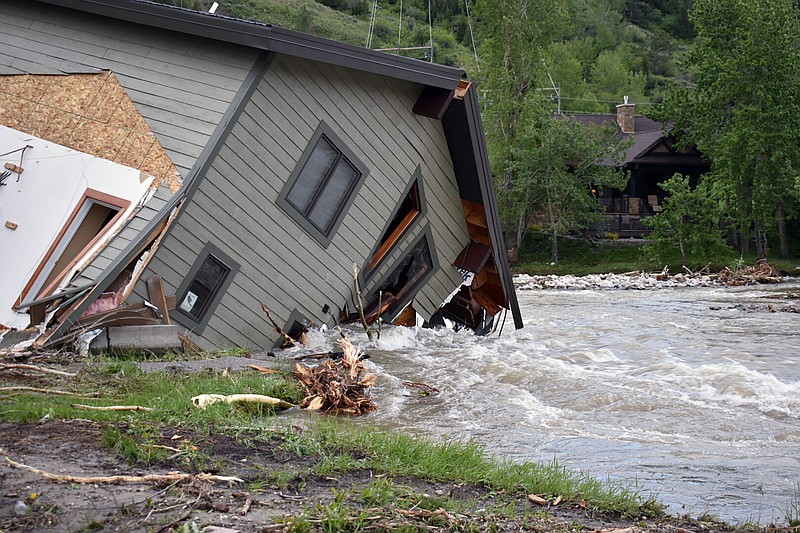 A house that was pulled into Rock Creek in Red Lodge, Mont., by raging floodwaters is seen Tuesday, June 14, 2022. Officials said more than 100 houses in the small city were flooded when torrential rains swelled waterways across the Yellowstone region. (AP Photo/Matthew Brown)