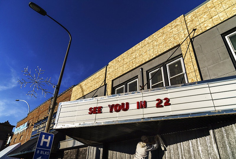 A worker polishes a marquee at a theater under renovation in Benson, Minn., in this Nov. 29, 2021 file photo. Benson, with a population just over 3,000, is among the rural communities that could benefit from the State Small Business Credit Initiative approved in 2021. (AP/David Goldman)