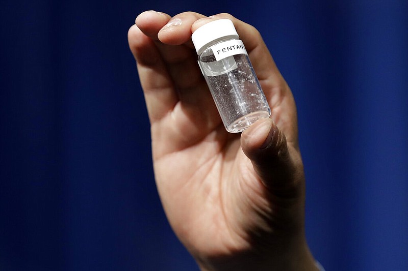 A reporter holds up an example of the amount of fentanyl that can be deadly after a news conference about deaths from fentanyl exposure at the headquarters of the Drug Enforcement Administration in Arlington, Va., in this June 6, 2017 file photo. (AP/Jacquelyn Martin)