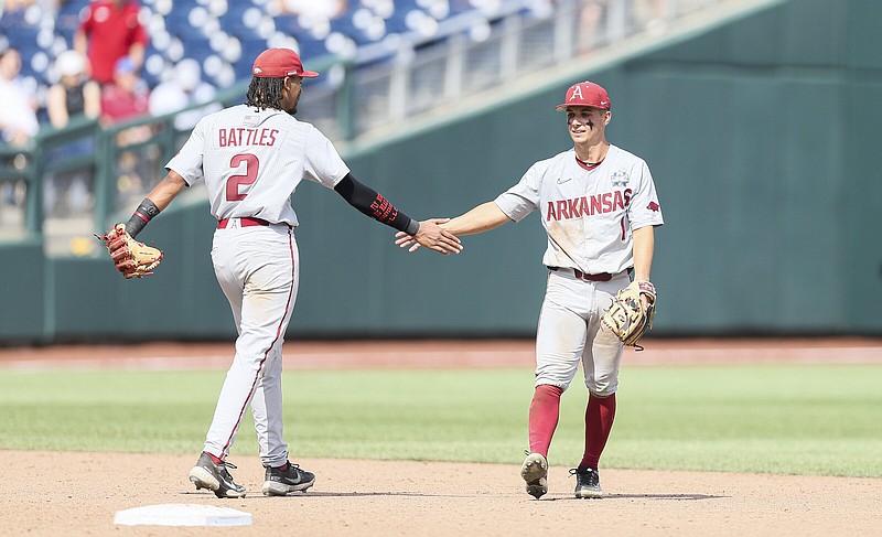 Arkansas second baseman Robert Moore (right) and shortstop Jalen Battles celebrate during the ninth inning of the Razorbacks’ victory over Stanford on Saturday at the College World Series in Omaha, Neb. The Razorbacks will next play in a winners bracket game Monday. More photos available at arkansasonline.com/619omaha.
(NWA Democrat-Gazette/Charlie Kaijo)