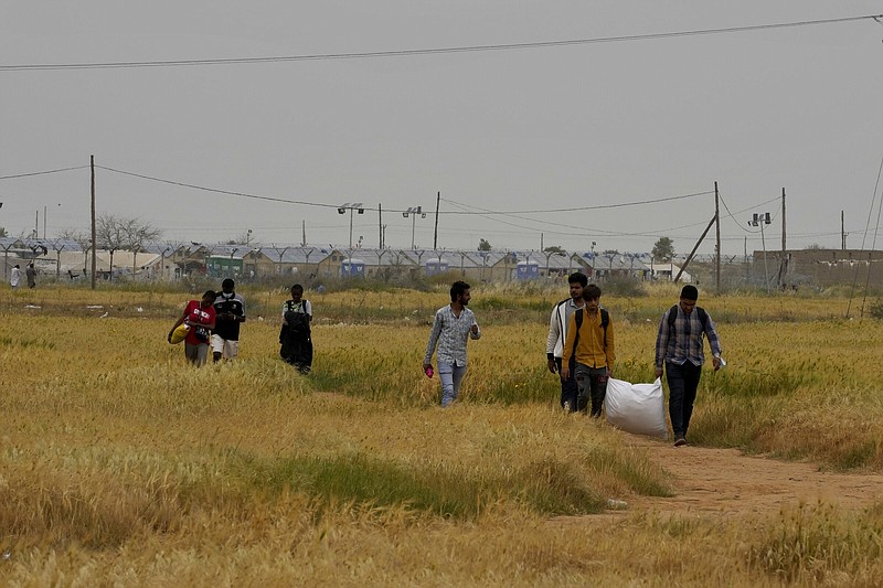 Migrants walk near the Pournara Emergency Reception center, in Kokkinotrimithia, on April 18 on the outskirts of the capital Nicosia, Cyprus.
(AP/Petros Karadjias)