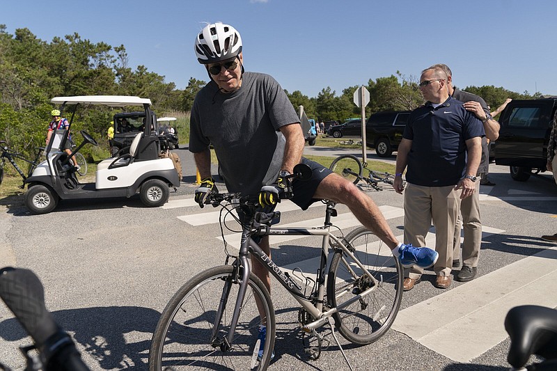 President Joe Biden gets back on his bike after he fell while trying to dismount Saturday to greet a crowd at Gordons Pond in Rehoboth Beach, Del.
(AP/Manuel Balce Ceneta)