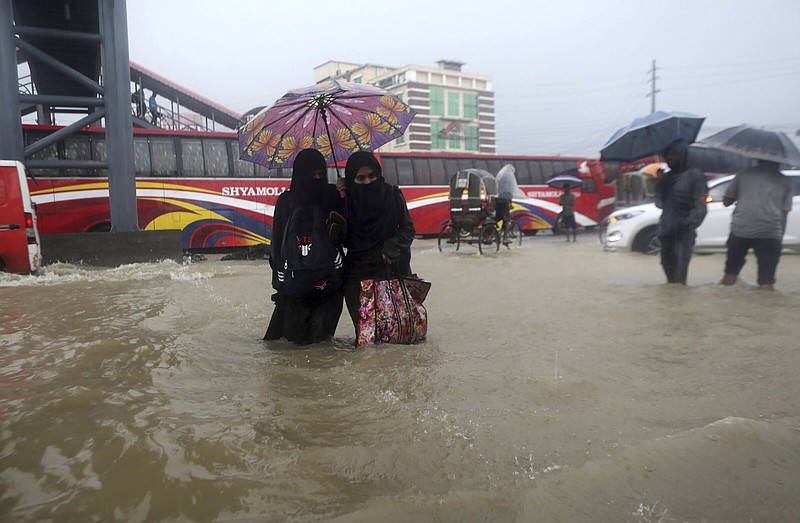 People wade through flooded waters Saturday in Sylhet, Bangladesh. At least 18 people have died as floods cut a swatch across northeastern India and Bangladesh, leaving millions of homes underwater.
(AP/Abdul Goni)