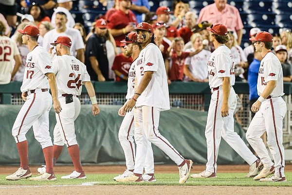 Arkansas players return to the dugout, Monday, June 20, 2022 at the end of the ninth inning of a NCAA College World Series double elimination game at Charles Schwab Field in Omaha, Neb. Visit nwaonline.com/220621Daily/ for the photo gallery.