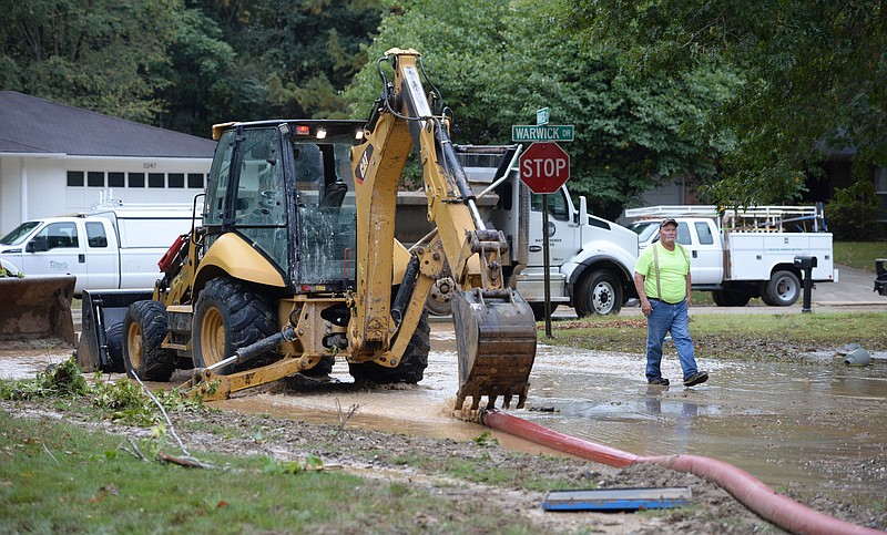 City of Fayetteville Water and Sewer Operations workers remove water Tuesday, Sept. 21, 2021, as they excavate beneath Makeig Court after what was identified at the scene as a 36-inch water transmission line beneath the street ruptured Monday evening. The line supplies water from the Beaver Water District to the city of Fayetteville. Visit nwaonline.com/210922Daily/ for today's photo gallery..(NWA Democrat-Gazette/Andy Shupe)